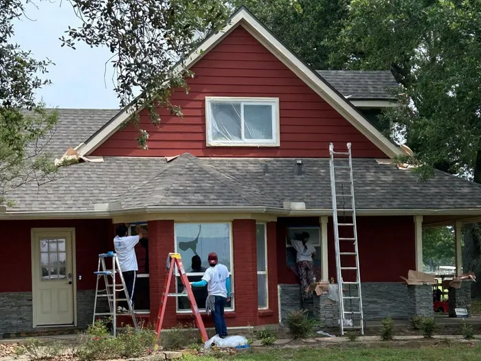 Exterior painting crew working on a red house in Houston