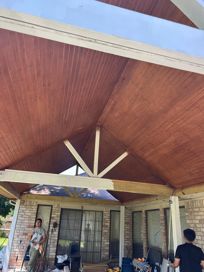 Crew staining a covered patio ceiling in Houston
